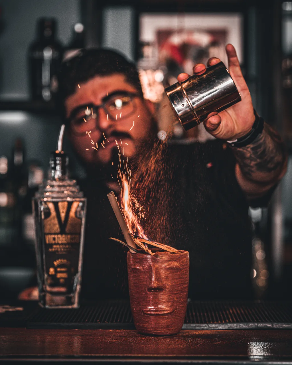 Bartender pouring fire into a Victorioso Mezcal cocktail