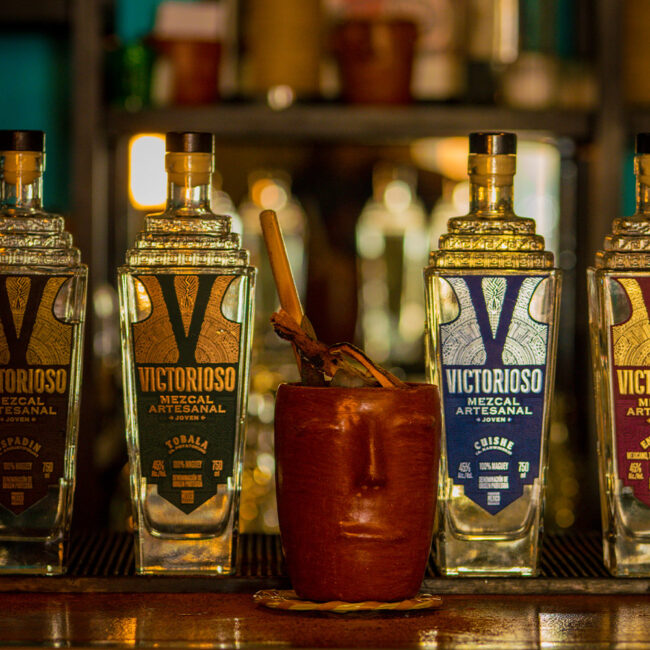 High-quality images of Victorioso Mezcal bottles, emphasizing the branding and the premium nature of the product.